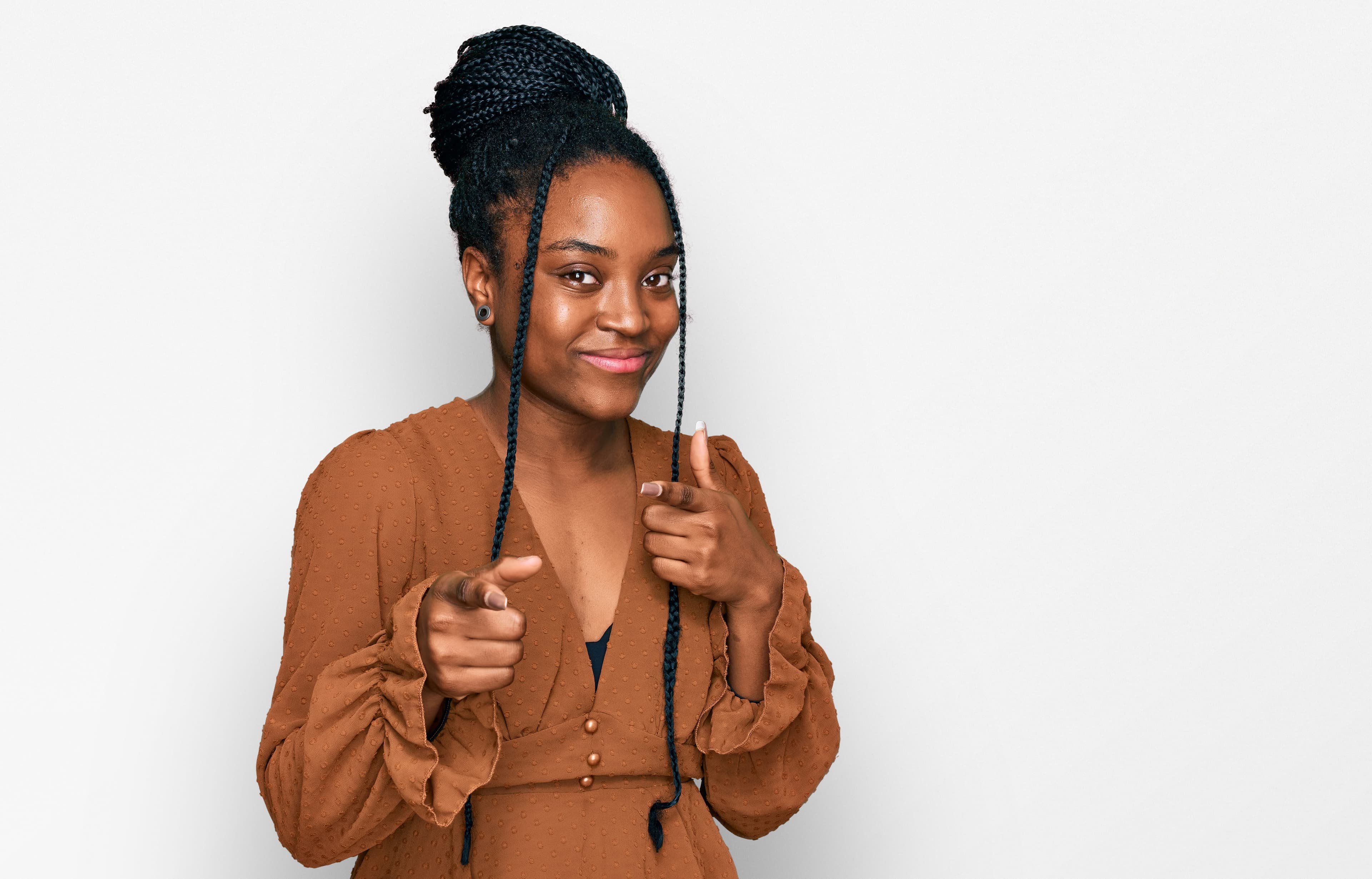African woman with braids smiling and pointing forward