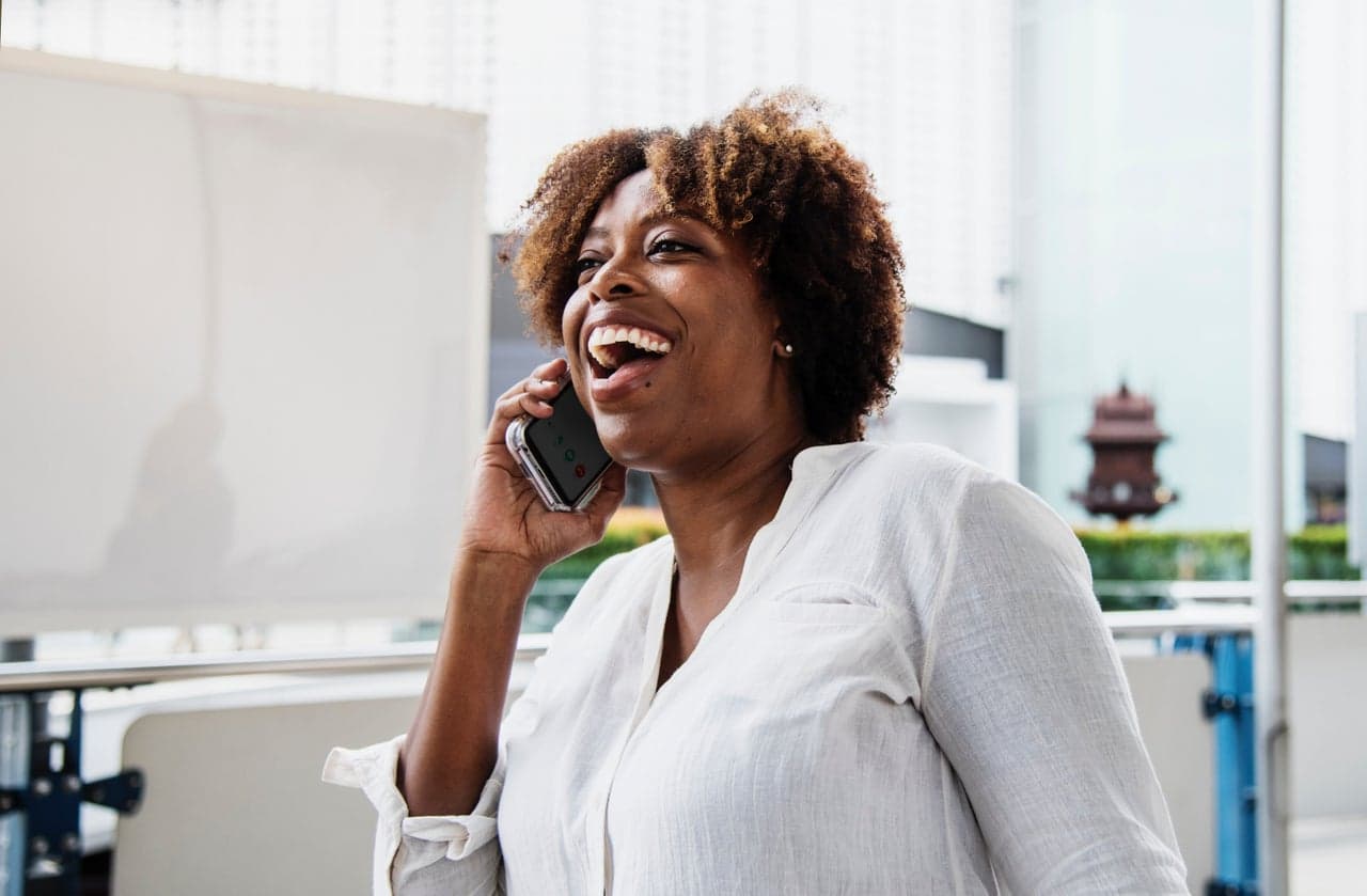 Happy African woman laughing on phone