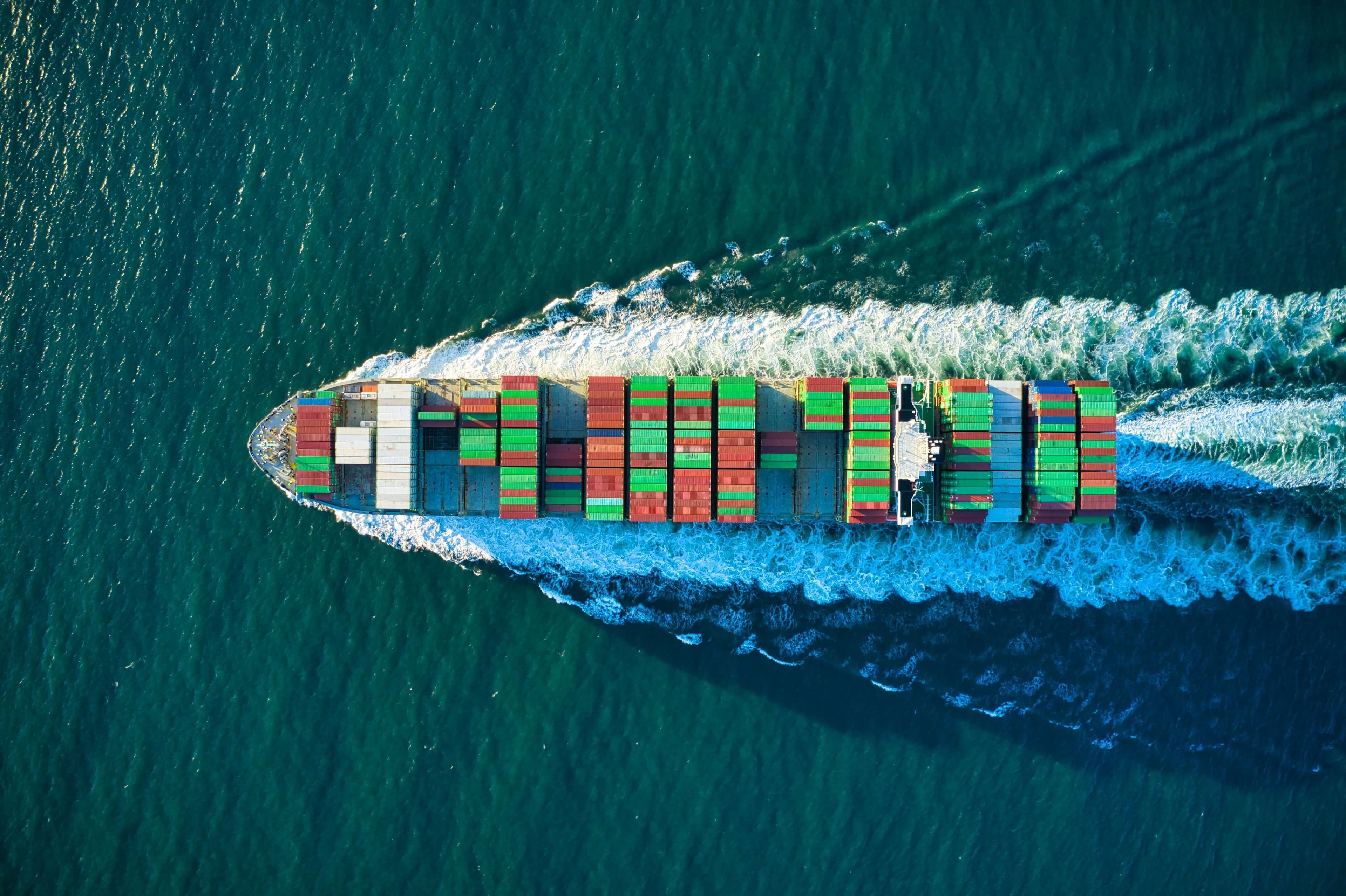 Aerial view of container ship cutting through ocean